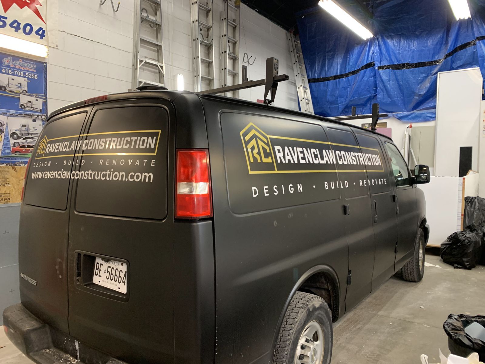 Matte black cargo van with a full wrap for Ravenclaw Construction, printed and installed by A1A Signs and Graphics in Mississauga